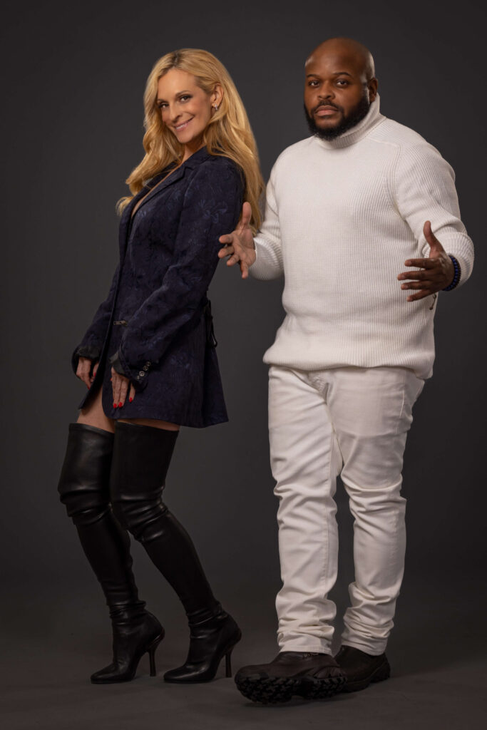 blonde woman smiling and man in white turtleneck posing in cool stance