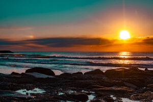 sunrise on Atlantic city beach in nj by rocks