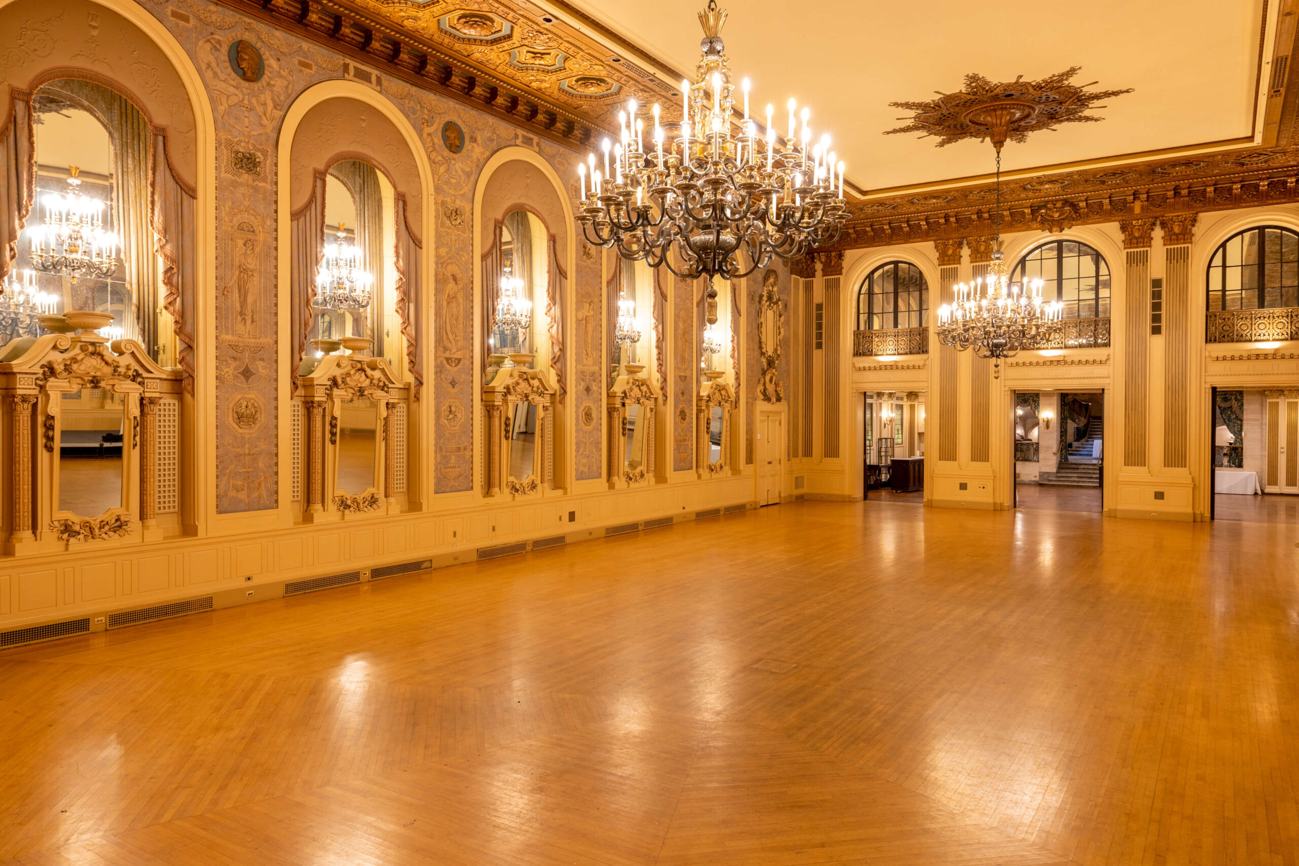 historical grand ballroom at hotel du pont with two large chandeliers and brown ceiling design