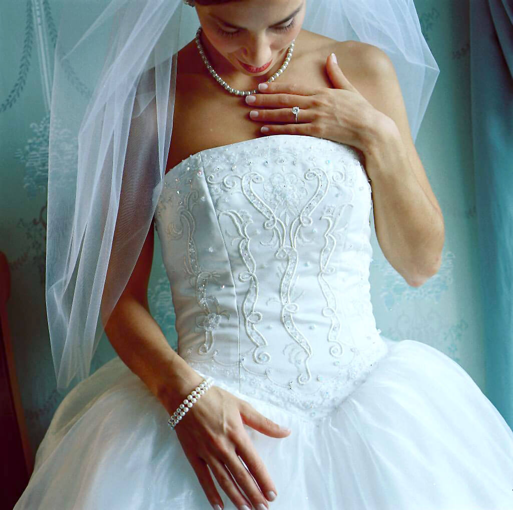 bride posing and appreciating at wedding dress details