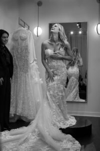 bride-to-be laughing and grabbing wedding dress during a bridal salon appointment