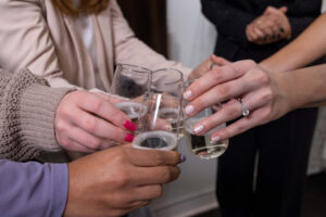 close up of women's hands celebrating with a champagne toast