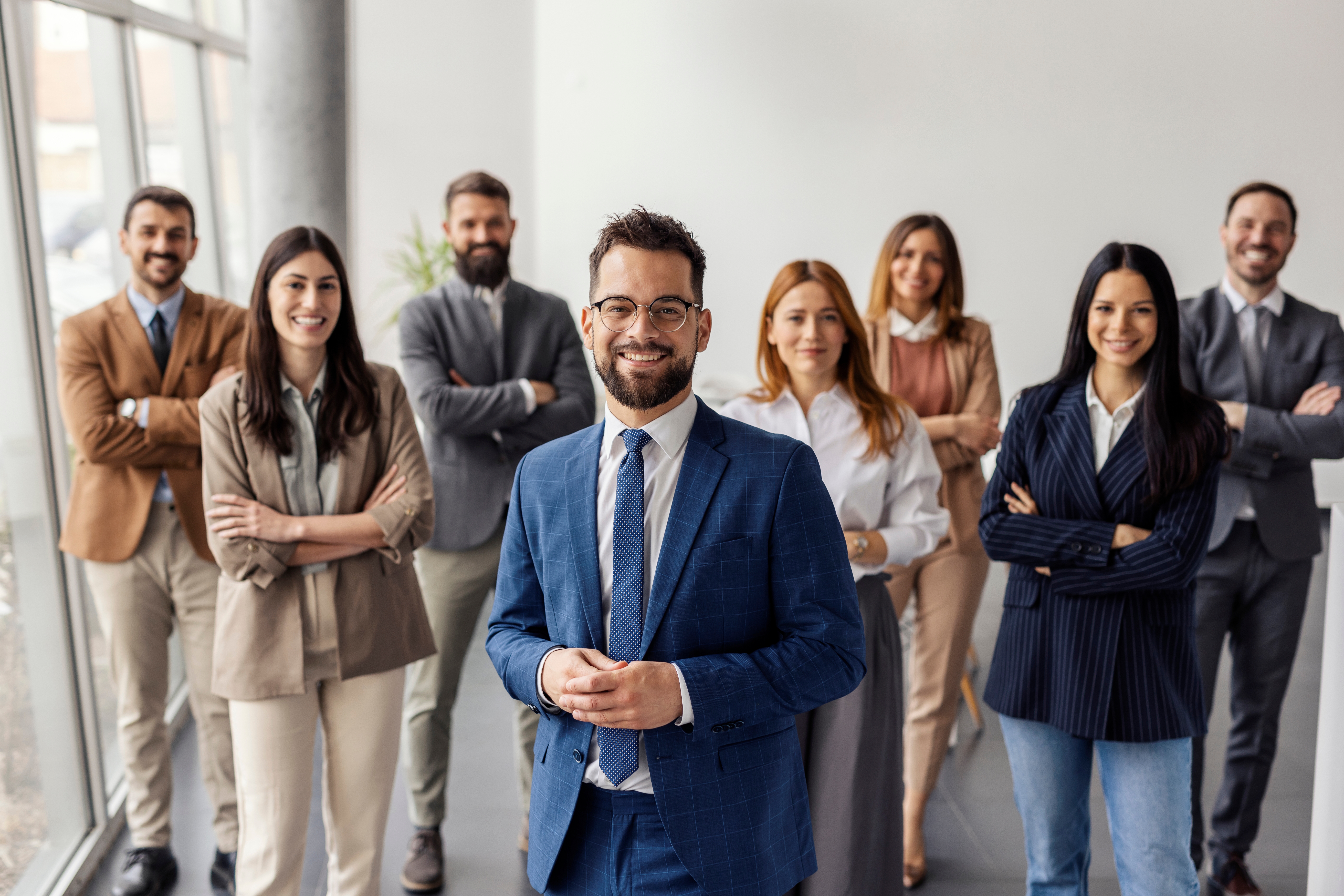 group photo of man and women team with marble pillars in background