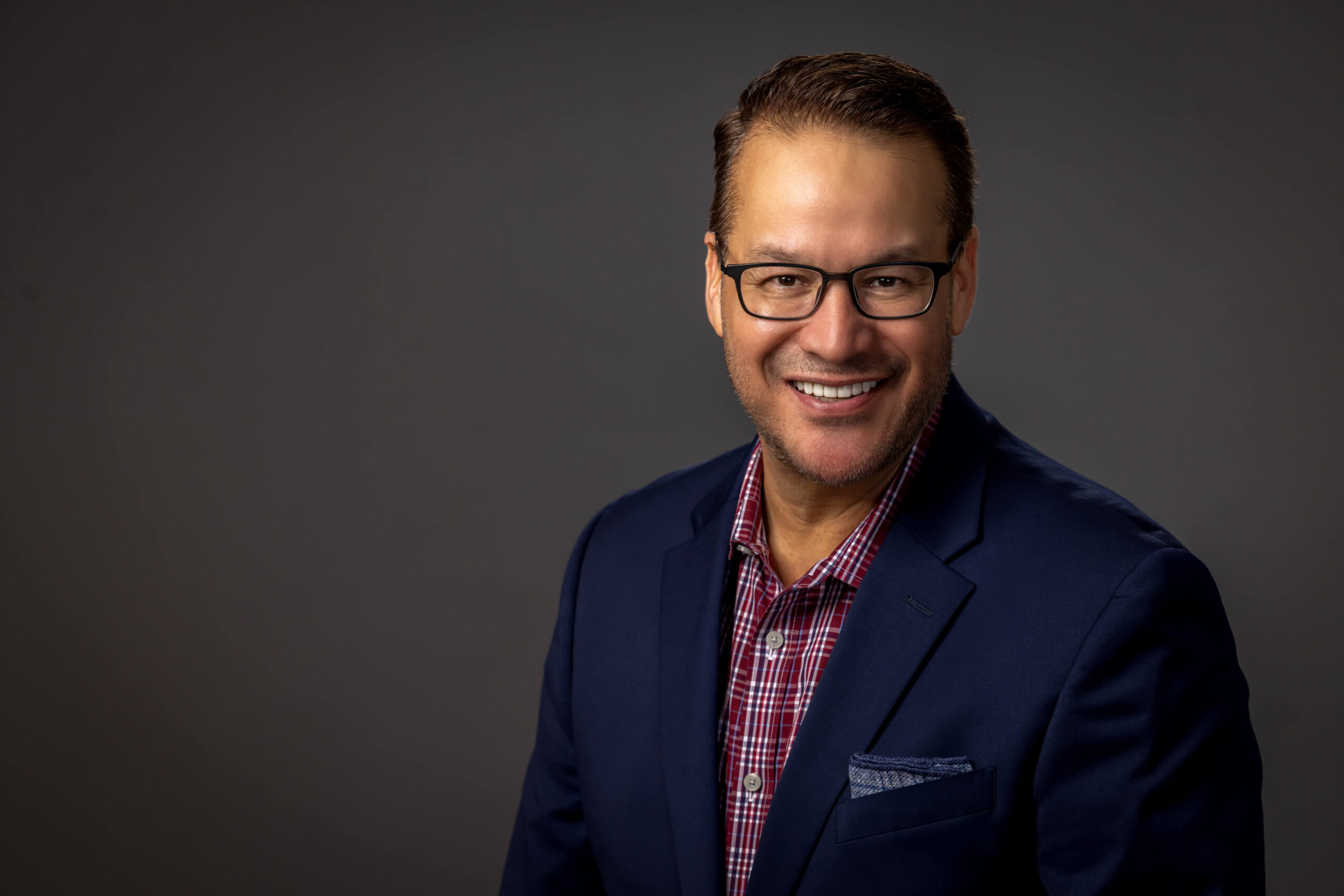 man posing with glasses and black blazer