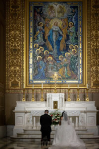 bride and groom pray to mary at catholic church wedding ceremony in philadelphia