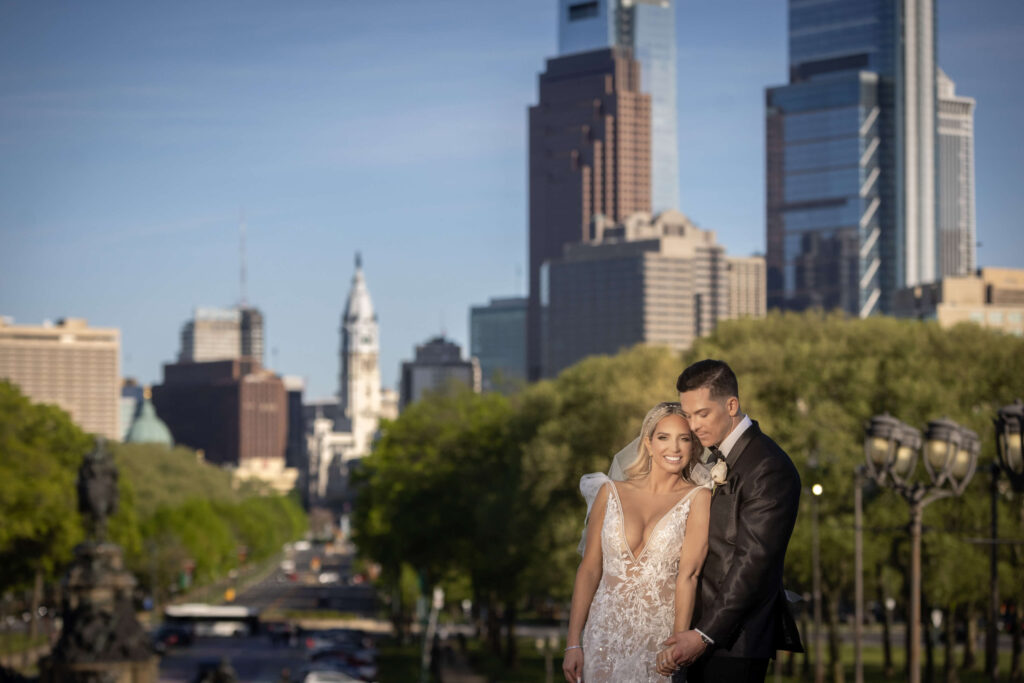 bride and groom pose together moment with dramatic philly skyline in background