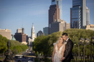 bride and groom pose together moment with dramatic philly skyline in background