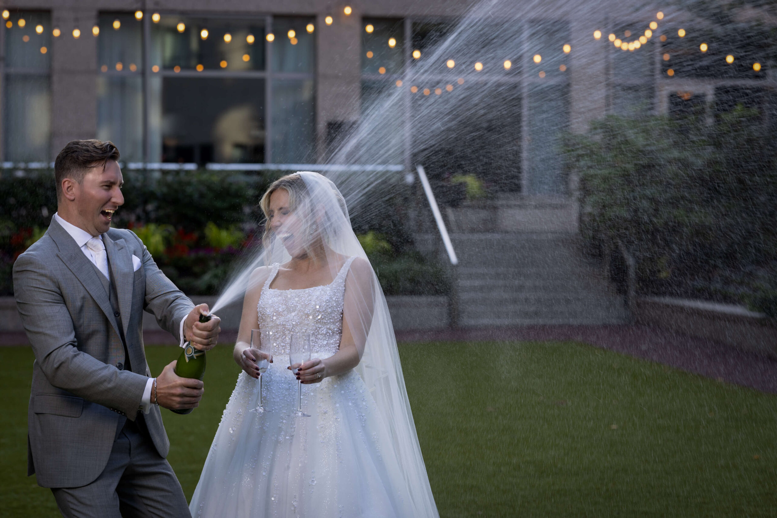 an exciting champagne pop with a bride and groom in the courtyard at The Logan in Philadelphia