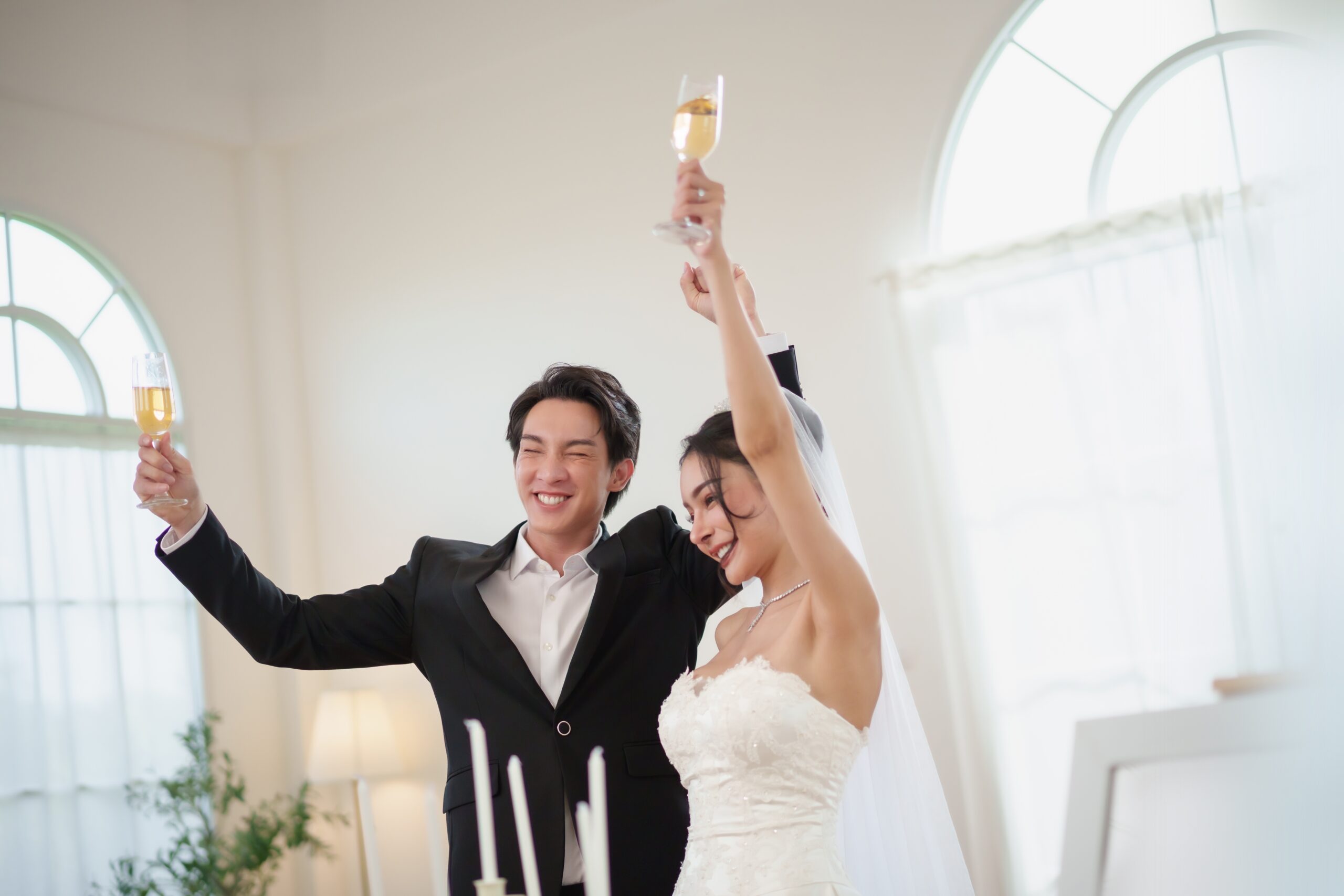 groom pops a bottle of champagne as the bride laughs at the logan hotel in philadelphia
