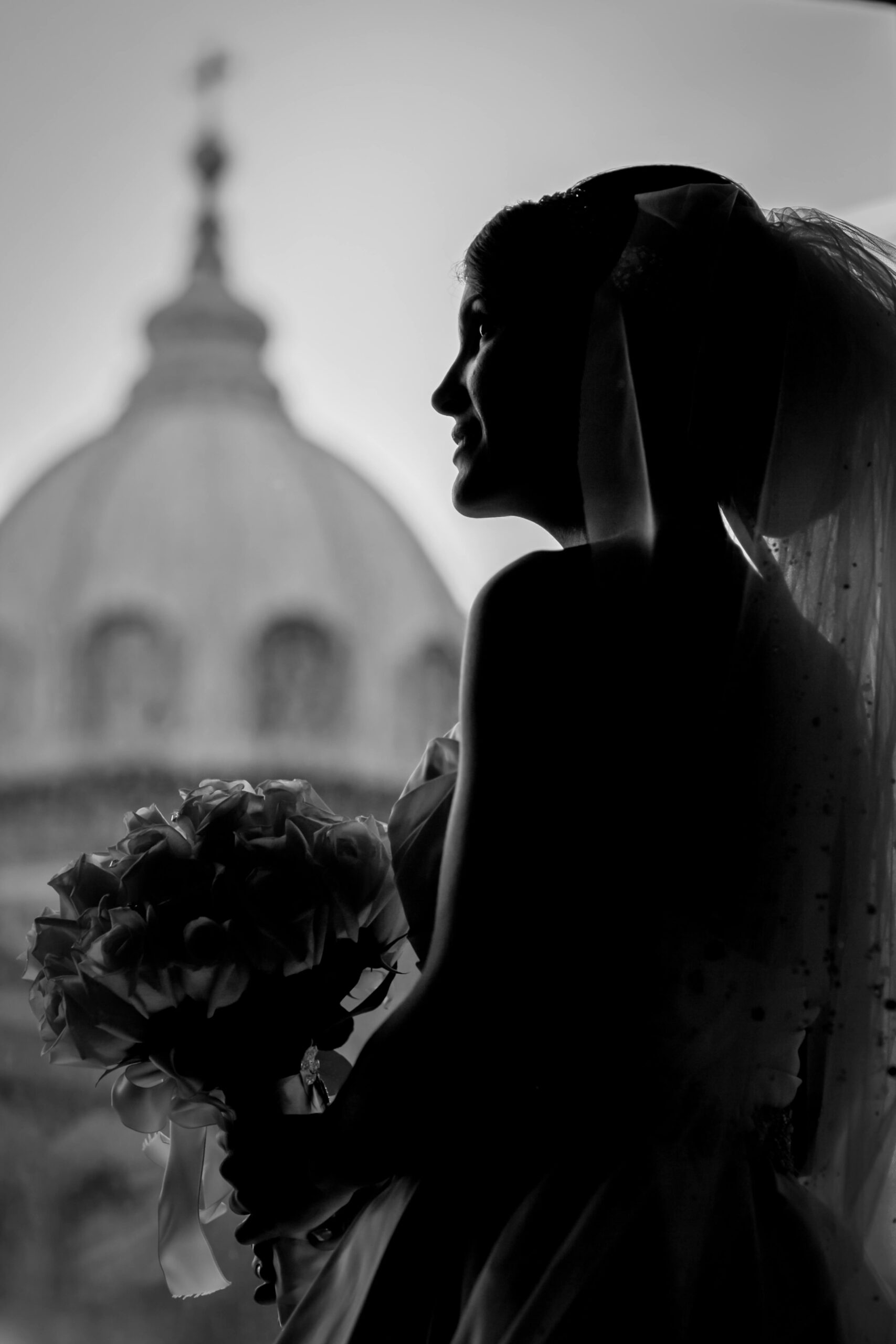 bride looking out the window to st. peter and paul from the pennsbury suite at the logan hotel
