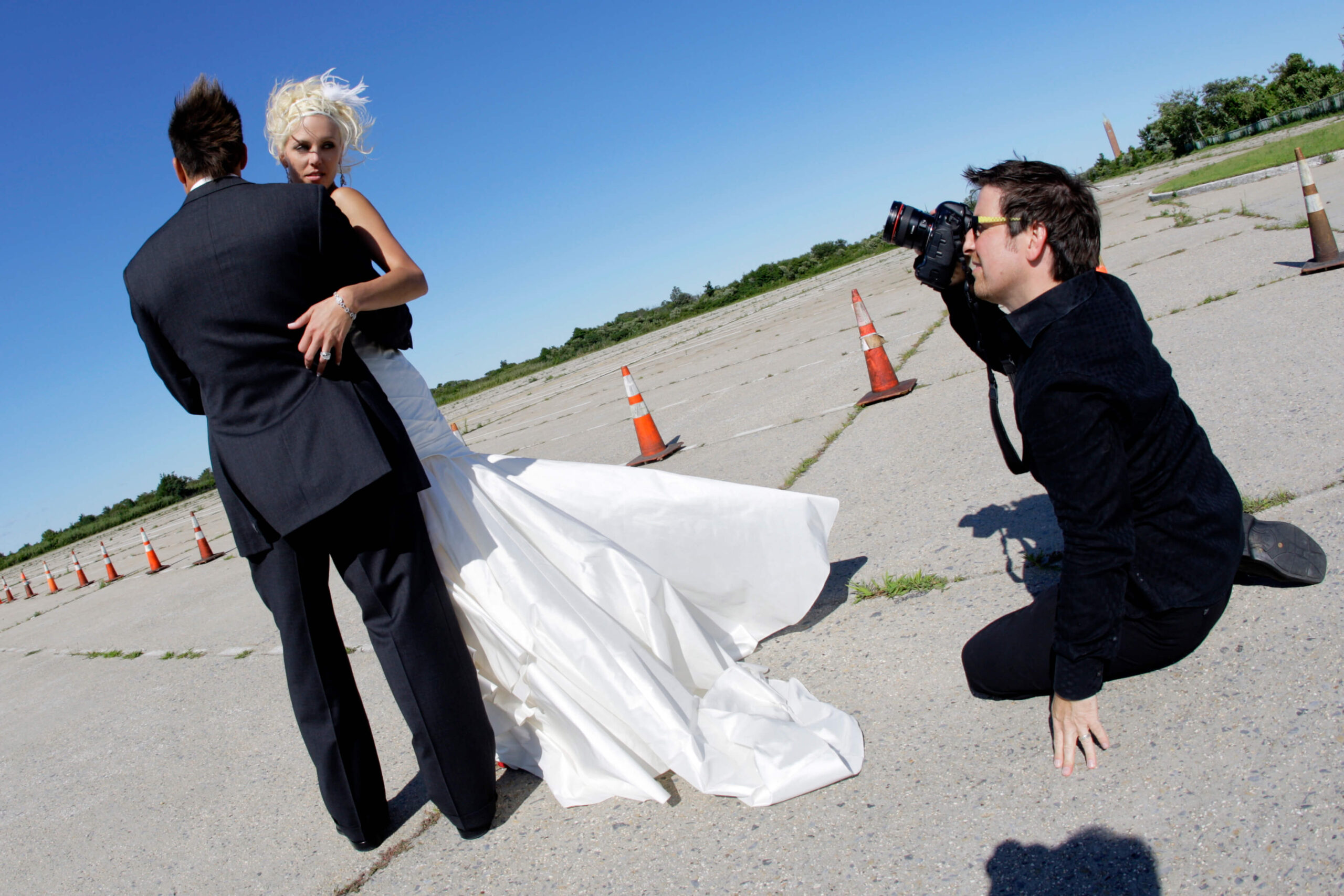 a photographer taking a picture of a woman in a wedding dress and man in suit