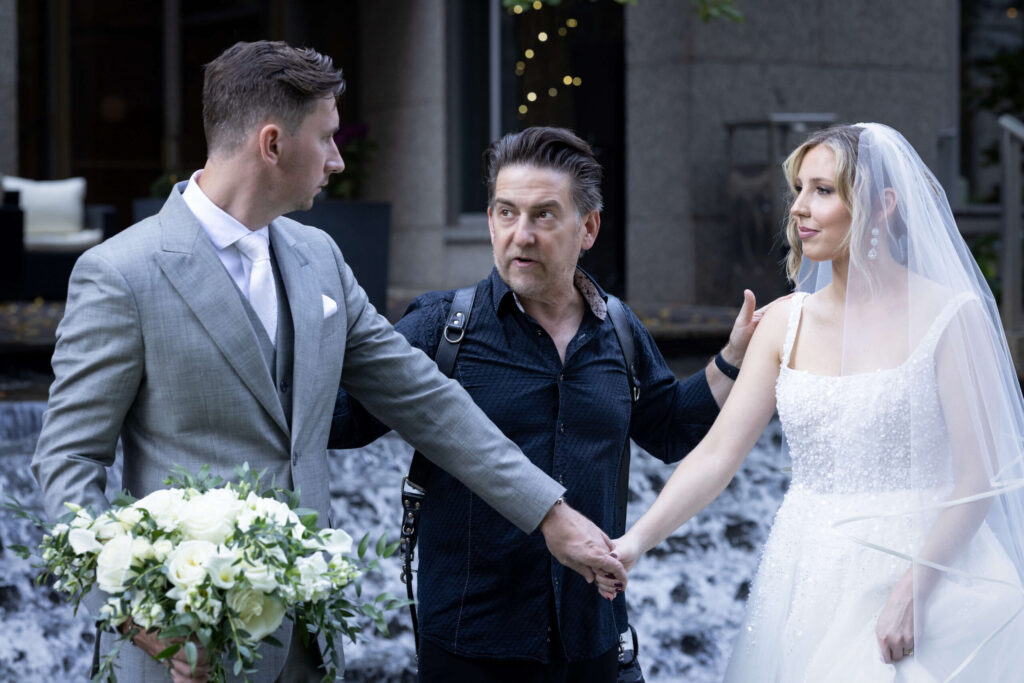 wedding photographer talking to a bride and groom at the logan hotel in philly