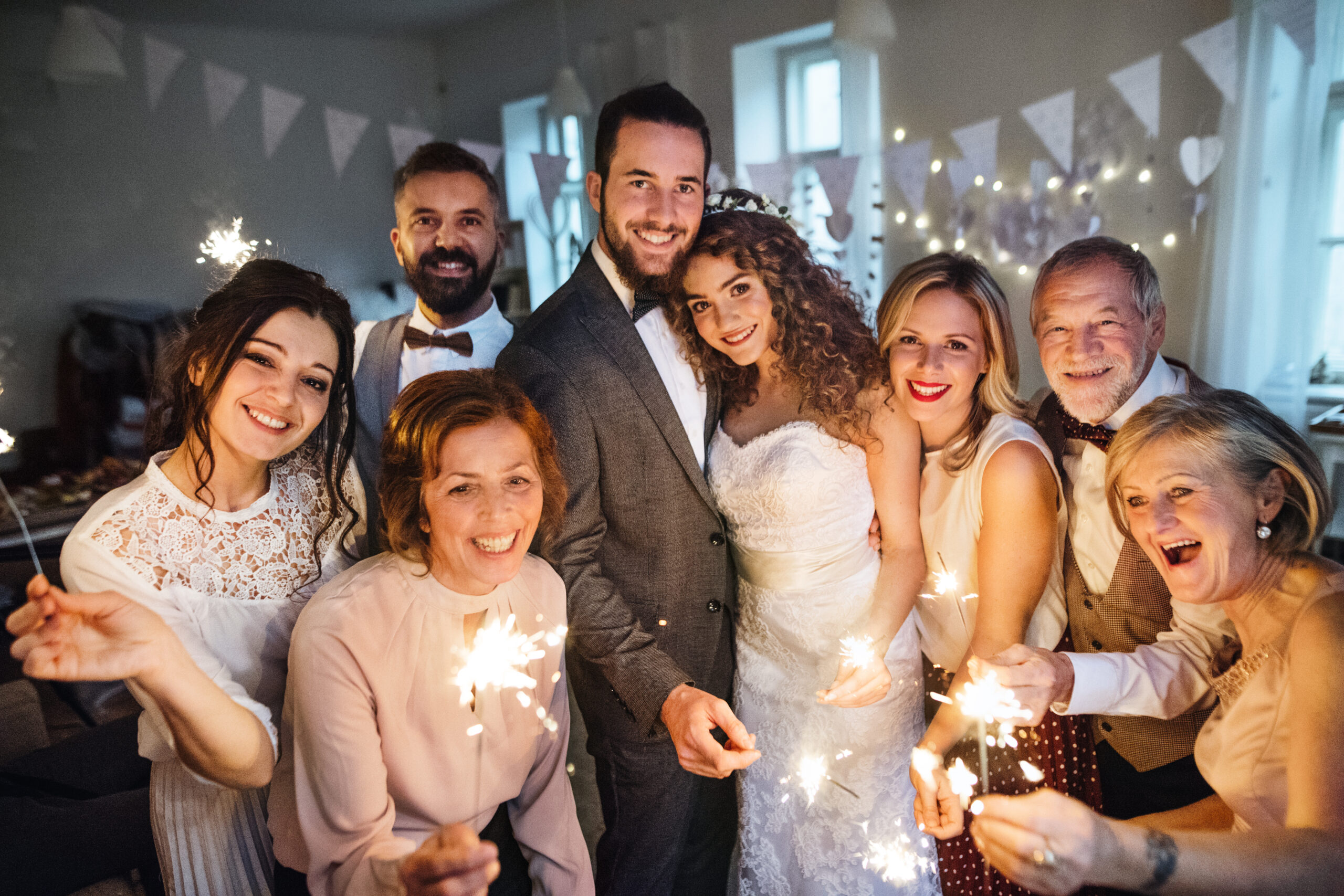 a bride, groom, and their family poses for a wedding photo in front of the altar