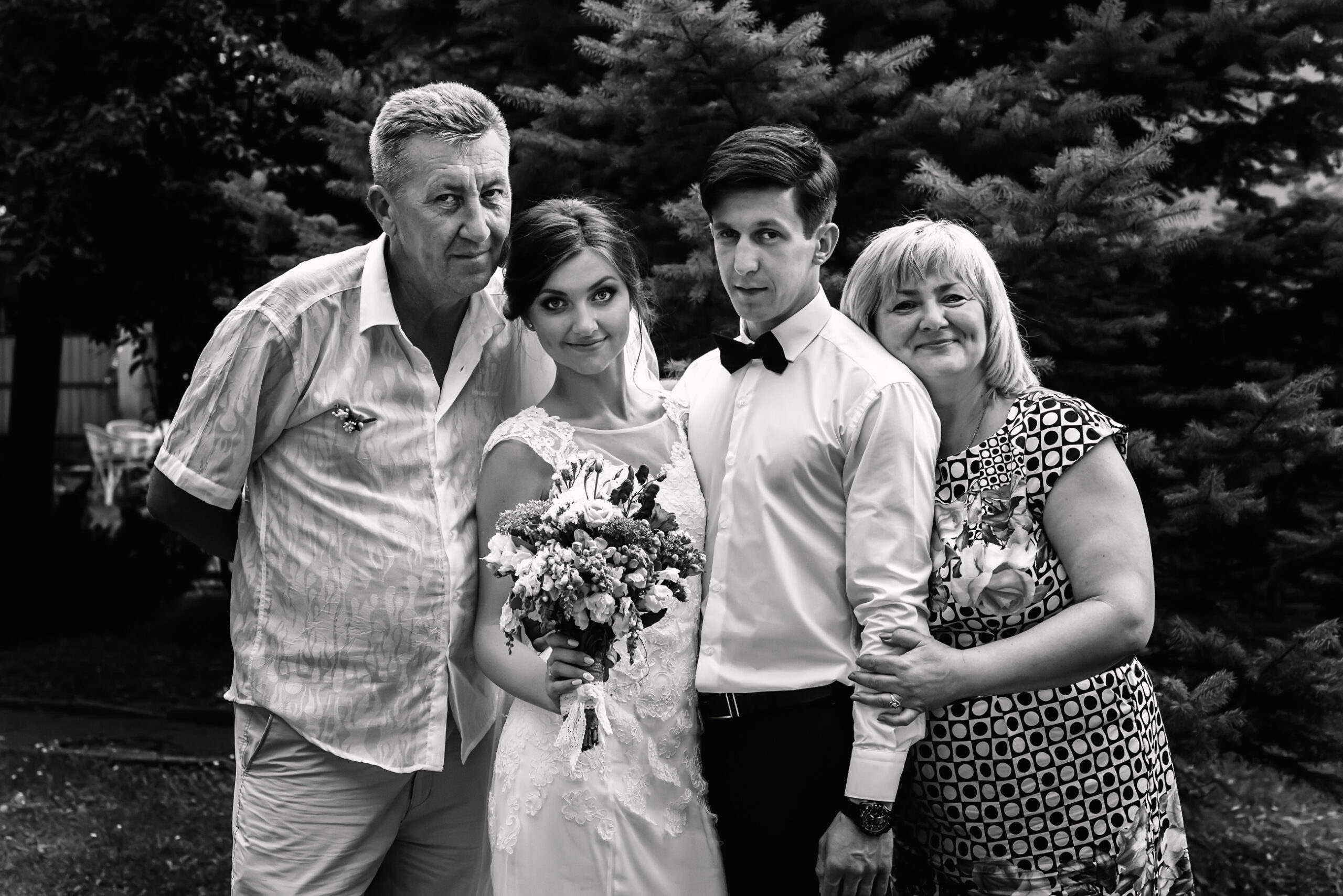 bride and groom posing and smiling for photos with their family