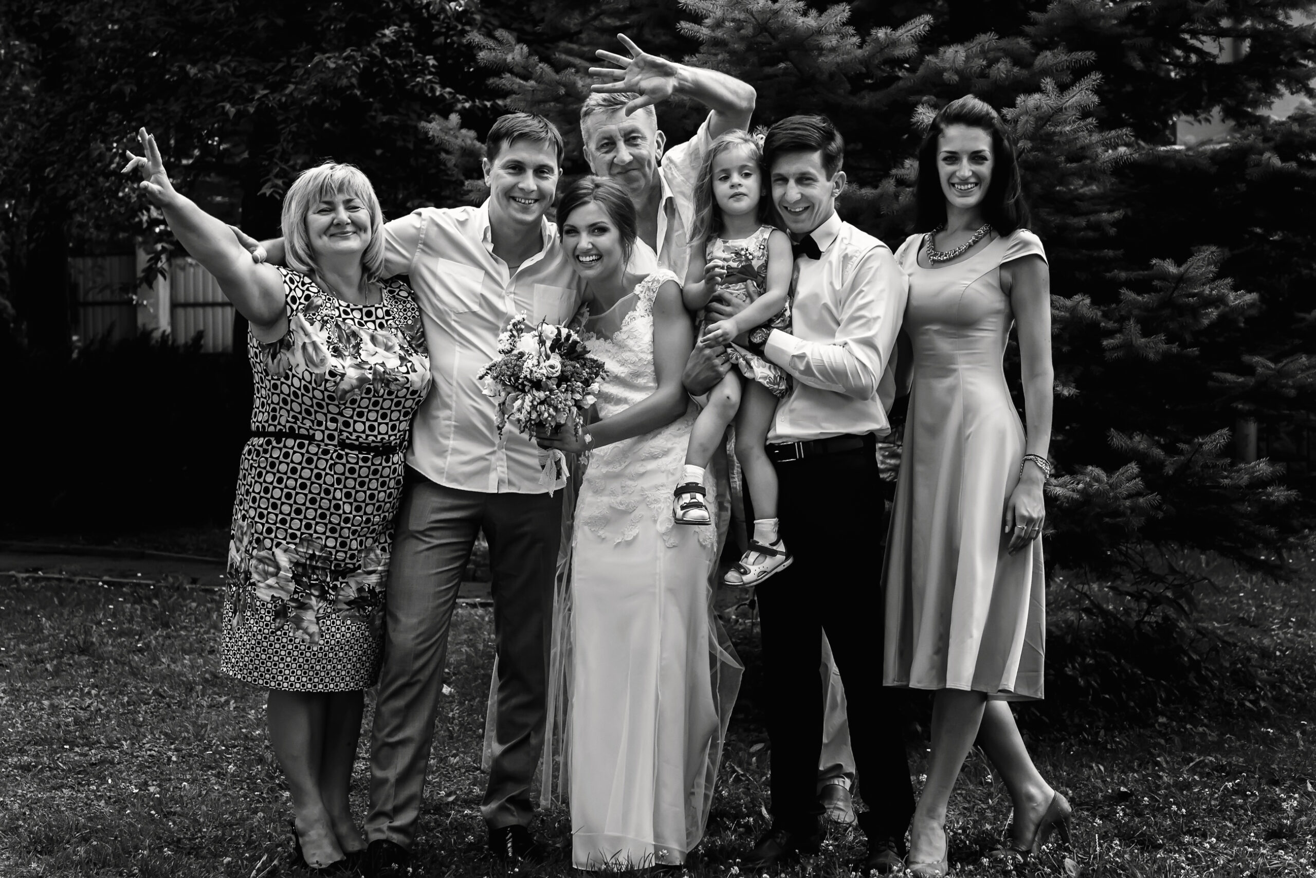 a bride and groom pose with their young men in suits