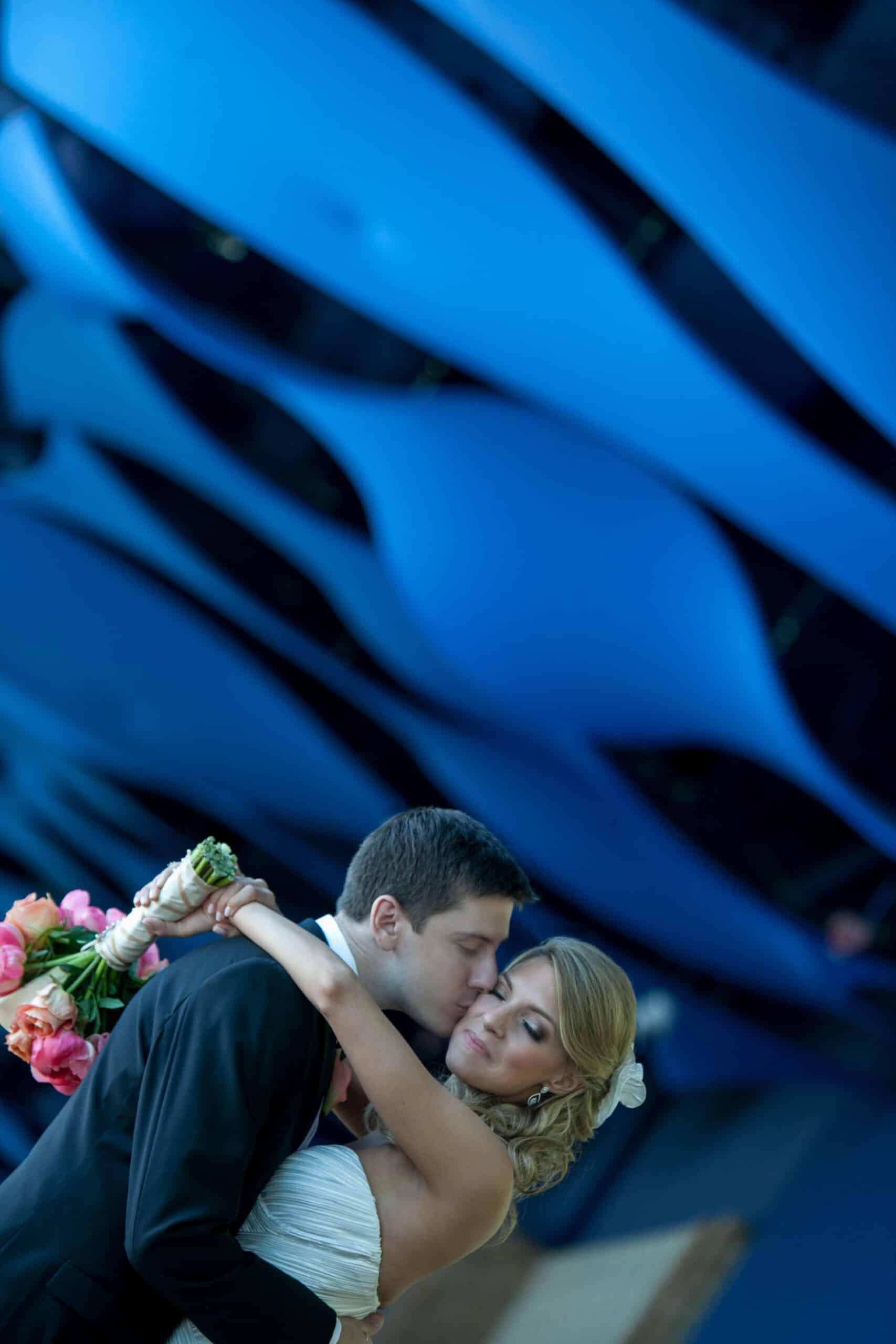 bride and groom kissing under a wavy blue ceiling
