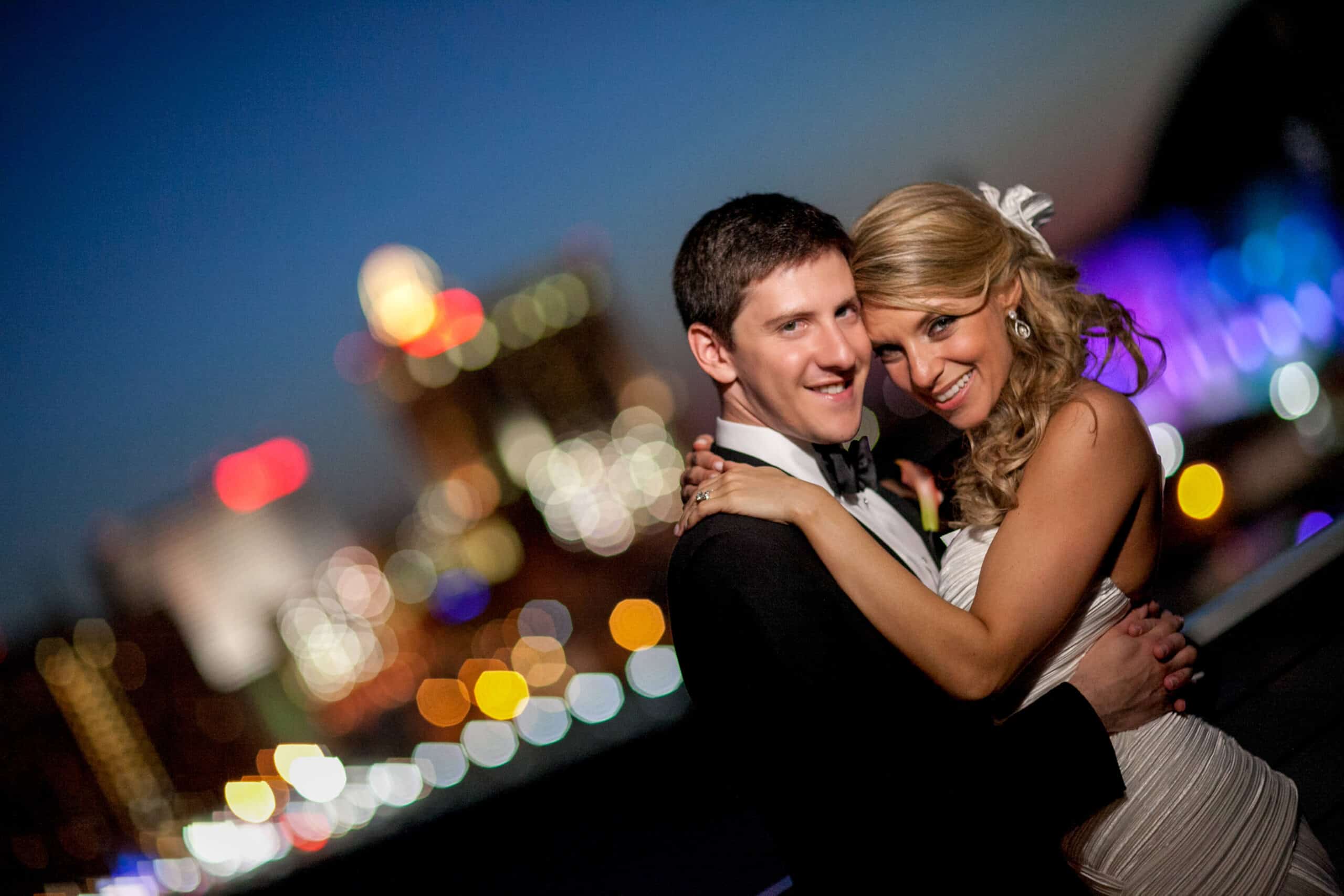 bride and groom embracing with AC skyline in the back
