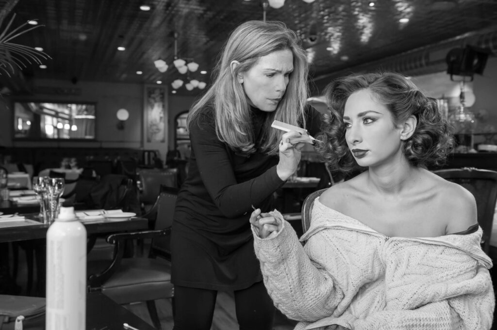 Artistic photography in philadelphia in black and white of a woman doing another woman's makeup