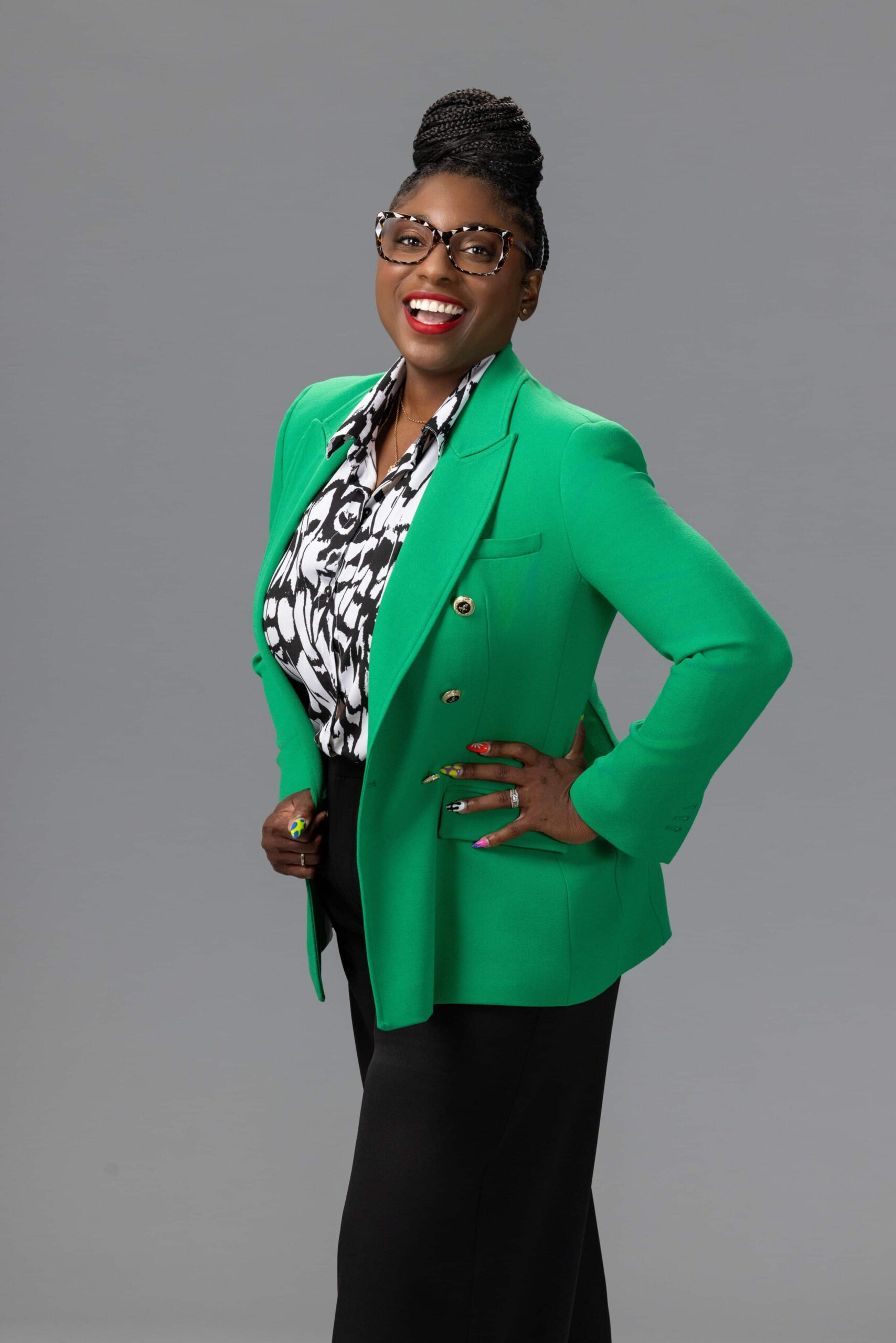 joyful woman laughing in a green jacket against a gray background