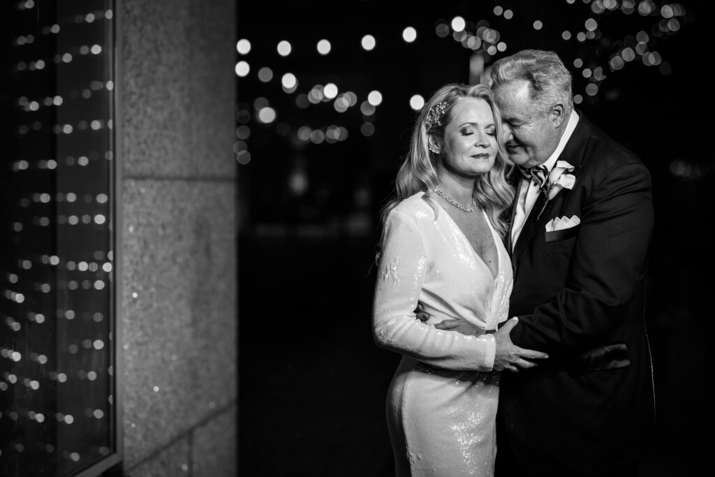 Bride and groom embracing during a romantic nighttime portrait session at The Logan Hotel courtyard in Philadelphia