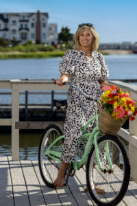 blonde woman posing on green bike by the bayside docks in new jersey