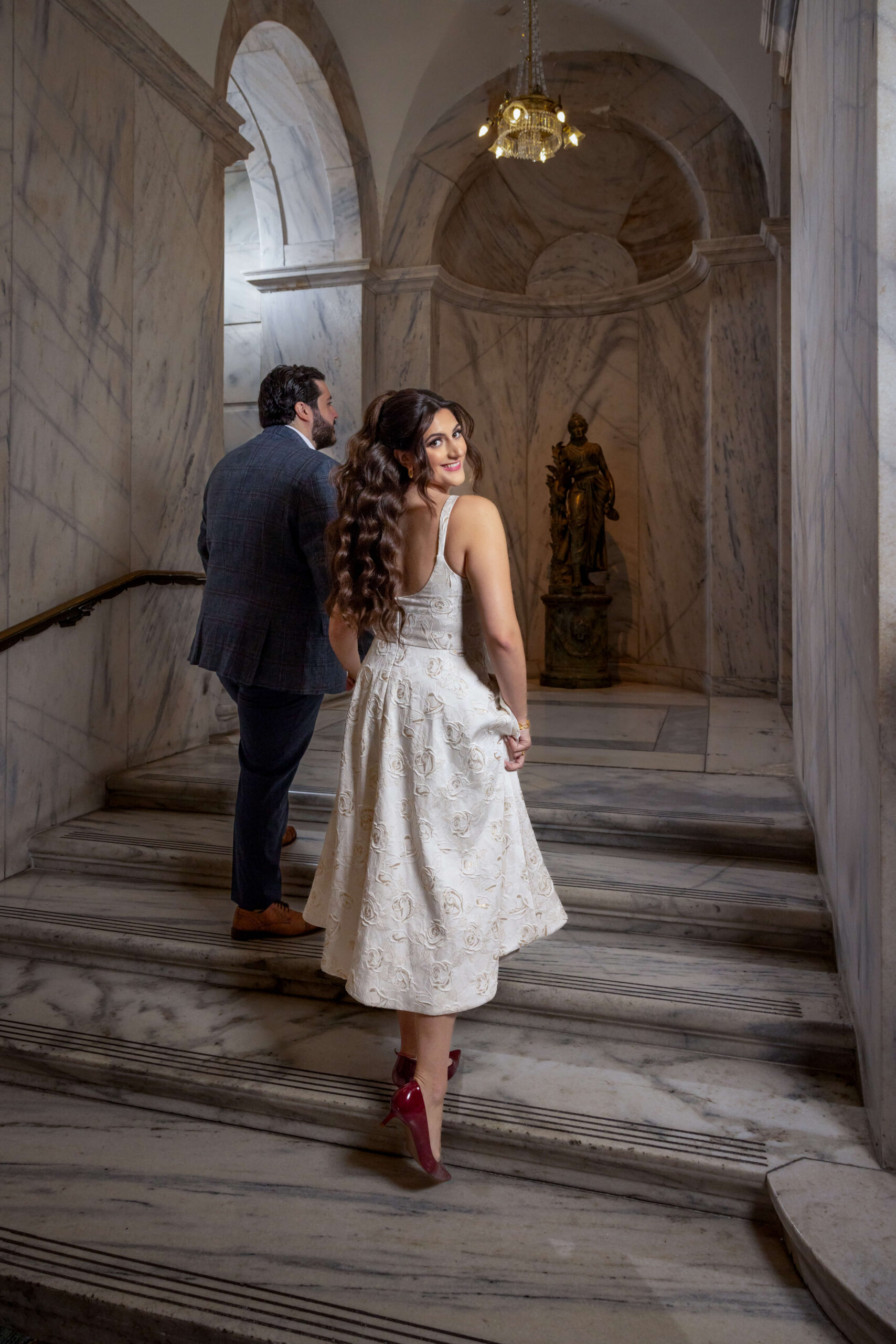 engaged couple walking up the marble stairs at ritz carlton ballroom in philly