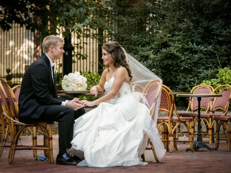 bride and groom hold hands at table