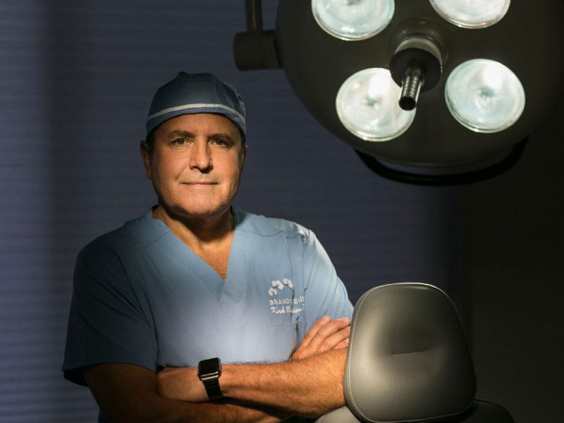 doctor in blue scrubs crossing arms